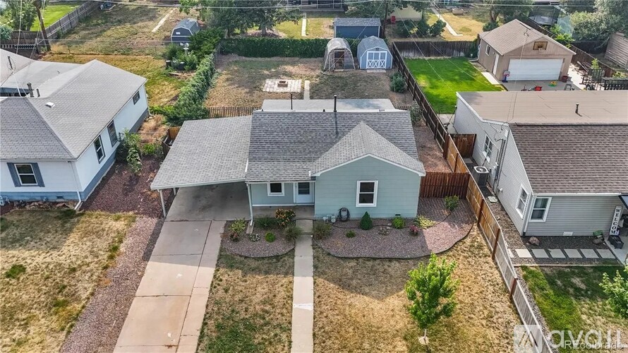 A bird's eye view of a residential area with a blue house in the center.