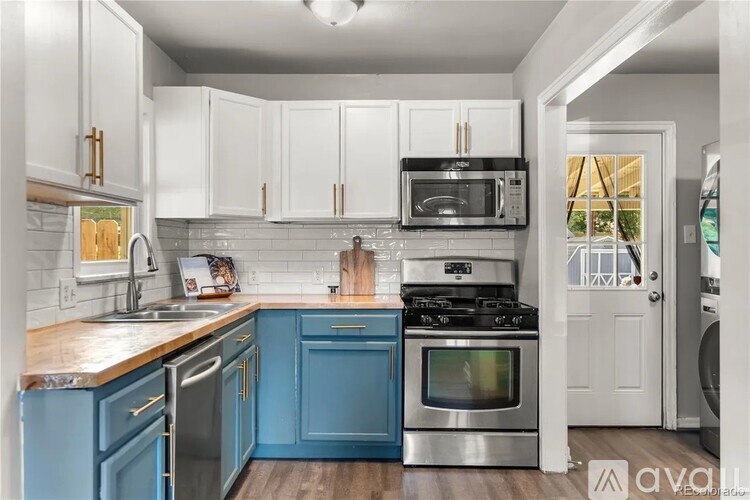 A kitchen with blue cabinets and stainless steel appliances.