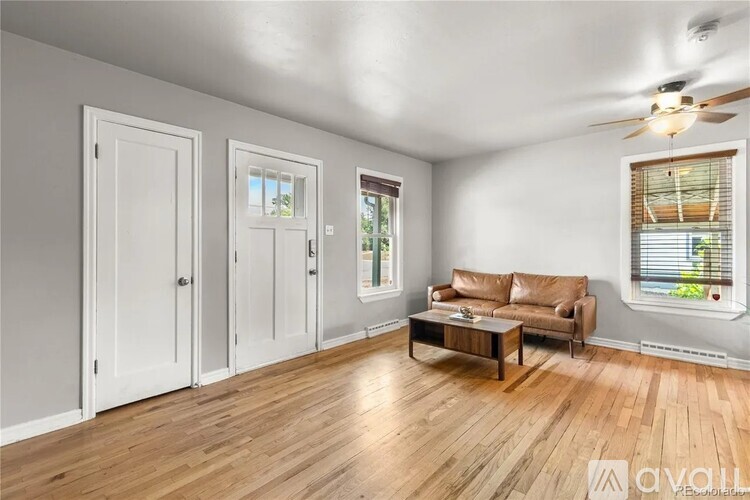 A living room with a brown couch and a ceiling fan.