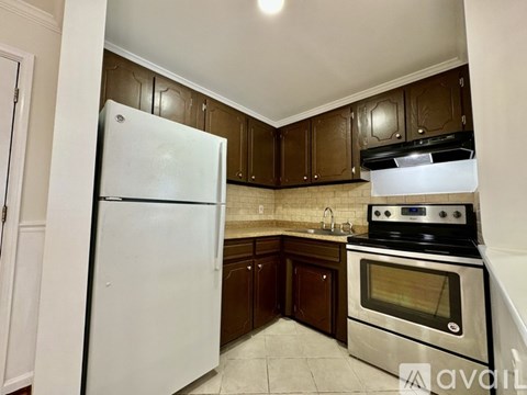 A kitchen with a white refrigerator and a stainless steel oven.