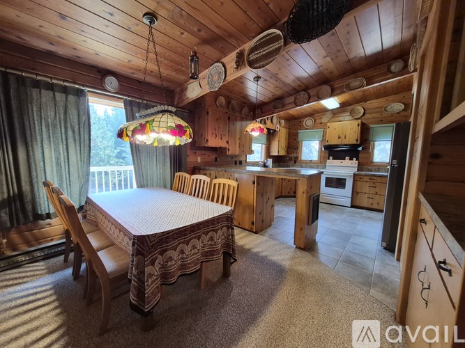 A wooden dining room with a round table and chairs.
