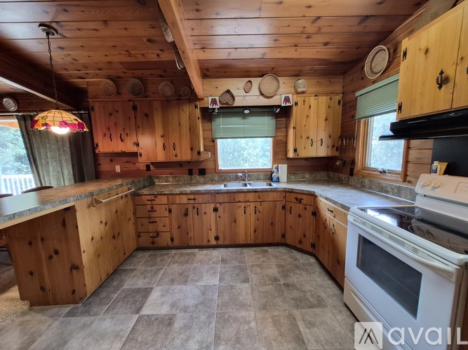 A kitchen with wooden cabinets and a large island.