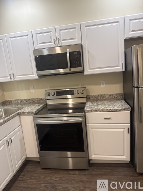 A kitchen with white cabinets and a granite countertop.