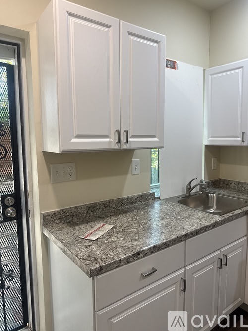 A kitchen with granite countertops and white cabinets.