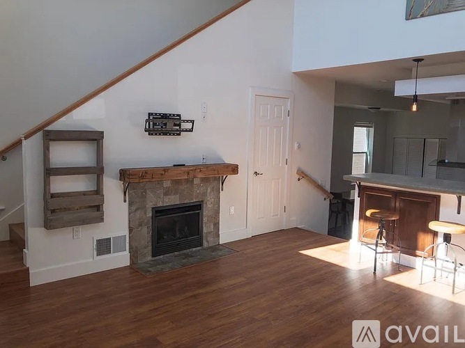 A living room with a fireplace and a bar area.