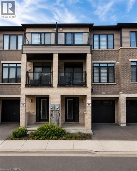 A modern apartment building with a balcony on the second floor.