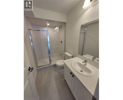 A bathroom with a toilet, sink, and shower.