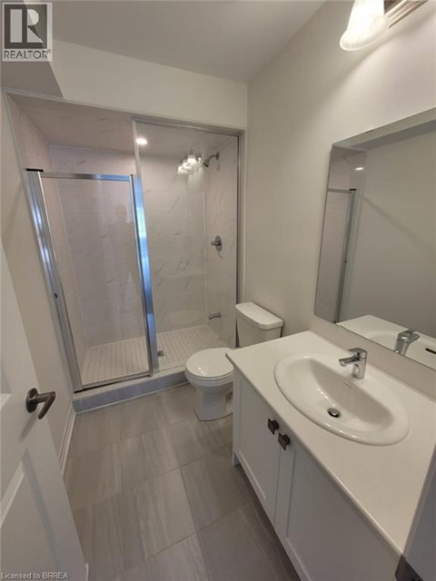 A bathroom with a toilet, sink, and shower.