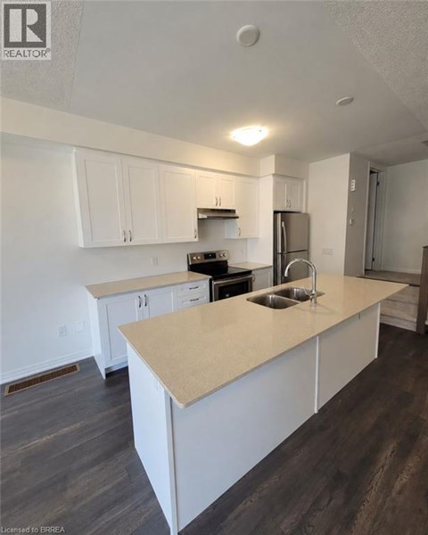 A kitchen with white cabinets and a beige island.
