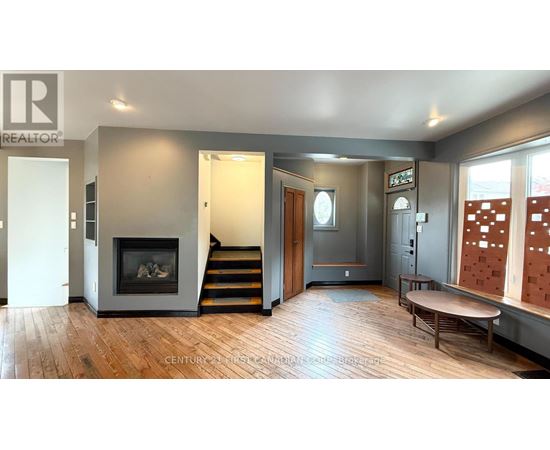 A living room with a fireplace and a wooden floor.