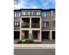 A building with a balcony on the second floor and garage doors on the first floor.