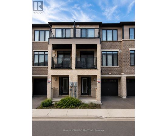A building with a balcony on the second floor and garage doors on the first floor.
