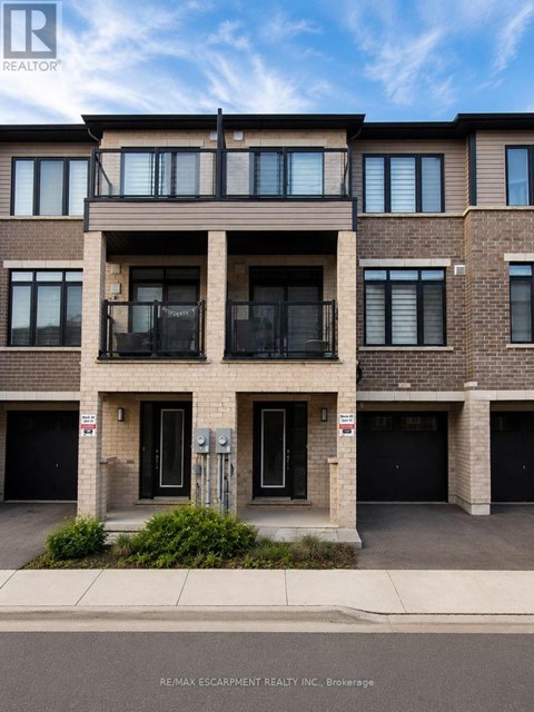 A building with a balcony on the second floor and garage doors on the first floor.