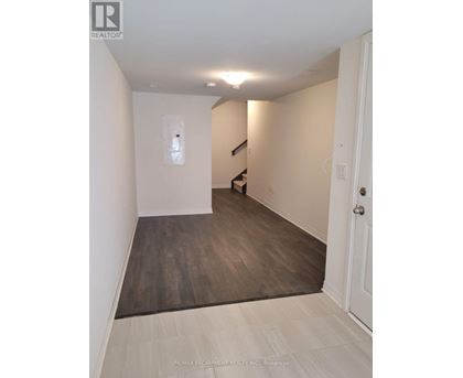 A hallway with a wooden floor and white walls.