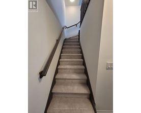 A staircase with a light switch on the wall.