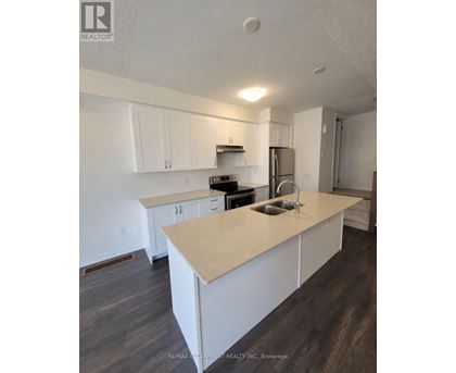 A kitchen with white cabinets and a beige island.