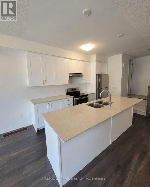 A kitchen with white cabinets and a beige island.