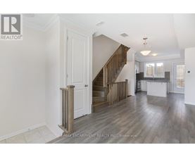 A spacious living room with a staircase leading to the upper floor.