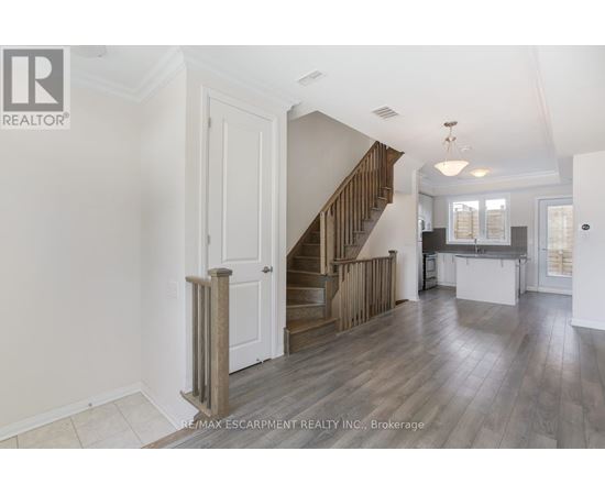 A spacious living room with a staircase leading to the upper floor.