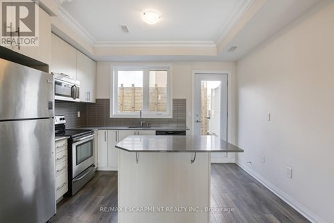 A modern kitchen with a stainless steel refrigerator and microwave.