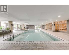 A large indoor swimming pool with the words "SHALLOW WATER" on the bottom.