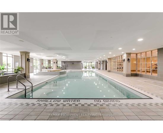 A large indoor swimming pool with the words "SHALLOW WATER" on the bottom.