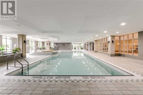 A large indoor swimming pool with the words "SHALLOW WATER" on the bottom.