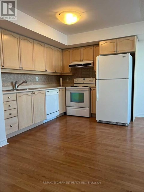 A kitchen with wooden cabinets and a white refrigerator.