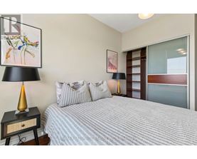 A bedroom with a bed, nightstand, and a painting on the wall.