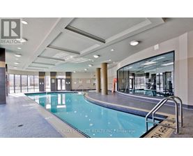 A large indoor swimming pool with a glass wall on one side.