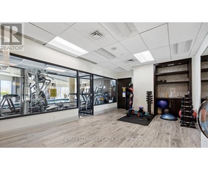 A gym with a variety of equipment including treadmills, weights, and exercise balls.