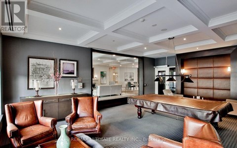 A living room with a grey carpet and brown leather chairs.