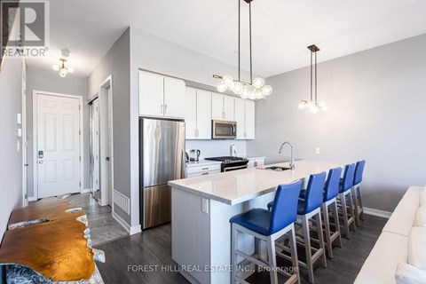 A kitchen with a long island and blue chairs.
