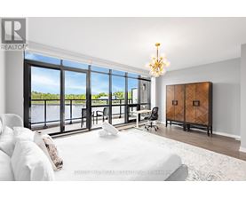 A bedroom with a large bed and a view of the water outside.