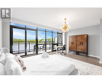 A bedroom with a large bed and a view of the water outside.