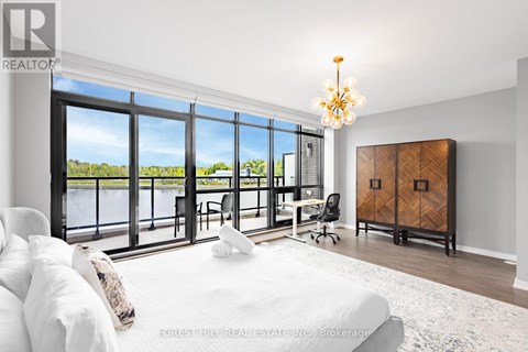 A bedroom with a large bed and a view of the water outside.
