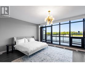 A bedroom with a large bed and a view of the water.