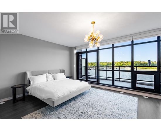 A bedroom with a large bed and a view of the water.