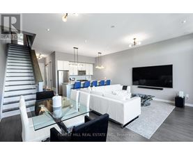 A modern living room with a glass table and white furniture.
