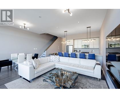 A modern living room with a white sofa and a glass coffee table.