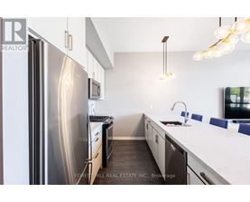 A modern kitchen with a stainless steel refrigerator and a white countertop.