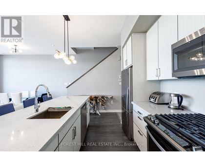 A modern kitchen with Forest Hill Real Estate Inc. logo.