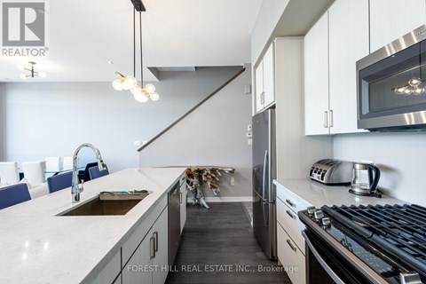 A modern kitchen with Forest Hill Real Estate Inc. logo.