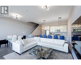A modern living room with a white sofa and a glass coffee table.