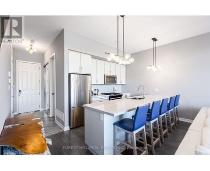 A kitchen with a long island and blue chairs.