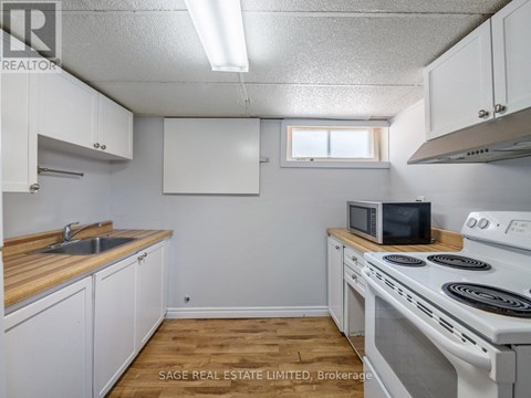 A small kitchen with white cabinets and a white stove top oven.