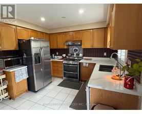 A kitchen with wooden cabinets and a stainless steel refrigerator.