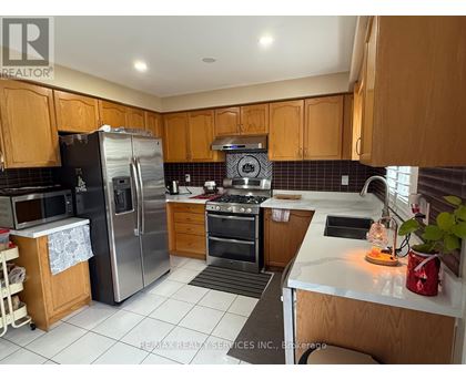 A kitchen with wooden cabinets and a stainless steel refrigerator.