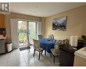A dining room with a table set for two and a painting of a mountain scene on the wall.