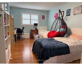 A bedroom with a bed, desk, and chair.